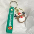 Nahaufnahme eines weihnachtlichen Rentier-Schlüsselanhängers mit grünem Silikonarmband - Rentierkopf mit Weihnachtsmütze