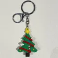 Detaillierte Nahaufnahme eines grünen Silikon-Weihnachtsbaum-Schlüsselanhängers mit Verschluss - Stern Rote Linie Stock Weihnachtsbaum Stil / Grün