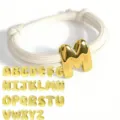 Detailansicht goldener Puffy-Buchstaben-Anhänger am weißen Kordelarmband, anpassbar. - Weißes Seil
