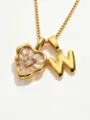 Close-up detail of gold stainless steel necklace with mother-of-pearl heart and letter W pendants. - Letter W