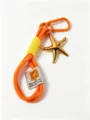 Handcrafted braided rope keychain with a gold starfish pendant and vibrant color block design. - Orange