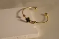 Exquisite gold-plated stainless steel cuff bracelet featuring a black clover motif and beads. - Black