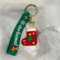 Nahaufnahme eines Weihnachtsstrumpf-Schlüsselanhängers mit grünem Band - Roter Stern Weihnachtsbaum & Socke