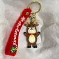 Nahaufnahme eines Weihnachts-Rentier-Schlüsselanhängers mit rotem Band und Goldverschluss. - Rentier mit Glocke