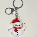 Nahaufnahme eines niedlichen Schneemann Schlüsselanhängers mit rotem Hut und Schal - Schneemann mit rotem Schal und Hut (22) / Weiß