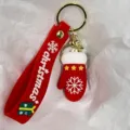 Detailansicht eines roten Weihnachts-Schlüsselanhängers mit Silikonband und Fäustling. - Weihnachtshandschuhe mit Sternen