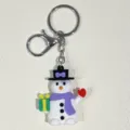Nahaufnahme eines Weihnachts-Schneemann-Schlüsselanhängers mit lila Schal und Geschenk - Schneemann mit lila Schal und Geschenk (28) / Weiß