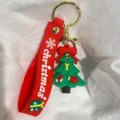 Detail eines festlichen Weihnachtsbaum-Schlüsselanhängers mit rotem Silikonband und Goldverschluss. - Weihnachtsbaum mit Socken und Handschuhen / Rot
