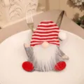 Close-up of a festive gnome cutlery holder on a white plate for Christmas dinner decor - Striped Hat (Gnome) / Striped