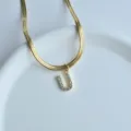 Close-up of the sparkling letter U pendant necklace with sleek flat herringbone chain detail. - Letter U