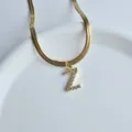 Close-up detail of the elegant gold snake chain necklace featuring a sparkling zircon letter Z. - Letter Z