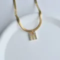 Gold stainless steel herringbone chain necklace featuring a sparkling cubic zirconia letter M pendant. - M
