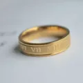 Nahaufnahme Detail des goldenen Edelstahlrings mit eingraviertem römischen Ziffern-Design. - Größe 6 / Gold