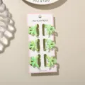 Set of 6 mini 3cm macaron green bow hair clips presented on a pink and white card. - 6 Pieces With Display Card / Pearlescent Grass Green