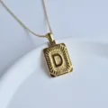 Close up detail of gold stainless steel initial letter D pendant necklace fashion accessory. - Letter D Cube Pendant / Gold