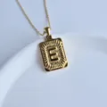 Close-up detail of the stylish gold stainless steel square letter E pendant necklace. - Letter E Square Pendant / Gold