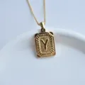 Detail close-up of gold stainless steel square letter Y pendant necklace with radiant texture. - Letter Y Square Pendant / Gold