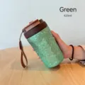 Nahaufnahme einer grün texturierten Kaffeetasse aus reinem Titan mit Trageriemen - 420ml / Grün