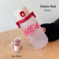 Primer plano de una botella de agua roja mate de 820 ml con correa blanca portátil - 820ml / Rojo Mate