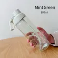 Mano sosteniendo botella de agua deportiva transparente verde menta de 880 ml con pajita - Verde menta