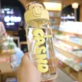 Close-up view of a transparent glass water bottle with yellow bounce lid and brand logo - 400ml / Lemon Yellow