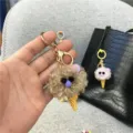 Close-up of a cute plush ice cream cone keychain with gold-toned metal clasp. - Single Piece / Khaki