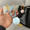 Close-up detail of a light blue plush pom-pom keychain with a flexible plastic loop - Single OPP Bag Packaging / Sky Blue