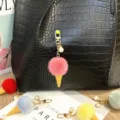 Close-up of colorful plush ice cream keychains with pearls on a black leather bag. - Single Piece / Rose Red