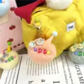 Detailed view of a soft plush ice cream charm with a floral bow on a quilted yellow bag - Single OPP Bag Packaging / Pink