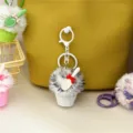 Close-up of a plush ice cream keychain with a cute white spoon and red bow detail. - Gray