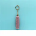Close-up detail of soft lavender plush tassel keychain with a gold-tone metal ring - Purple