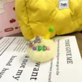 Detailed macro view of a cute yellow plush ice cream charm with a colorful floral bow - Single OPP Bag Packaging / Yellow