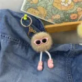 Close-up of a cute plush ball keychain featuring pink sunglasses and pink doll shoes. - Khaki