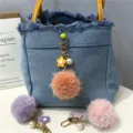 Detailed close-up of a colorful flower pom-pom keychain charm on a denim bag. - 1 Piece / Orange Red