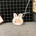 Macro view of a cute white plush rabbit keychain featuring a small orange hair clip - Single OPP Bag Packaging / Orange