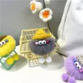 Group of colorful fuzzy soot sprite plush bag charms featuring knitted hats and big eyes - Gray