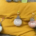 Detailed view of cute fuzzy soot sprite keychains featuring knitted hats and big eyes. - 1 Piece / Gray