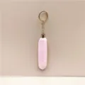 Detailed macro shot of a fluffy pink plush keychain with a shiny gold-tone metal ring. - Pink