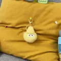 Close-up of a cute yellow plush soot sprite keychain with a knitted hat - 1 Piece / Goose Yellow