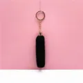 Detail view of the soft black plush tassel keychain with a durable golden ring attachment - Black