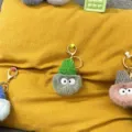 Macro view of cute plush coal ball keychains with tiny colorful knit hats and big eyes - 1 Piece / Dark Green