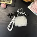 Detailed view of white plush bag charm featuring a black balloon dog and heart clasp - White
