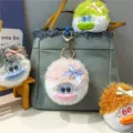 Cute fuzzy exploded hair plush doll keychains in various colors hanging on a denim bag - Pink