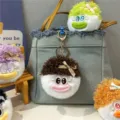 Süße plüschige Puppen-Schlüsselanhänger mit buntem Haar als Deko an einer Tasche - Kaffeebraun