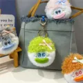 Detailansicht von bunten, flauschigen Plüschpuppen-Schlüsselanhängern an einer Tasche - Grün
