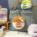 Bunte und süße flauschige Plüschpuppen-Schlüsselanhänger an einer Denim-Handtasche - Orange