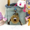 Quirky brown plush doll keychain featuring pigtails, hanging as an accessory on a denim bag - 1 Piece / Khaki