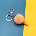 Adorable plush ice cream cone keychain with peach pom-pom on blue and yellow background - Single OPP Bag Packaging / Off White