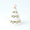 Elegante gorro de fiesta blanco con forma de cono, patrones dorados y un pompón rosa arriba - Gorro Blanco Con Estampado Dorado y Pompon
