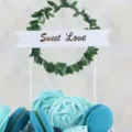Close-up detail of forest style green leaf wreath cake topper with Sweet Love banner - Green Leaf Sweet Love